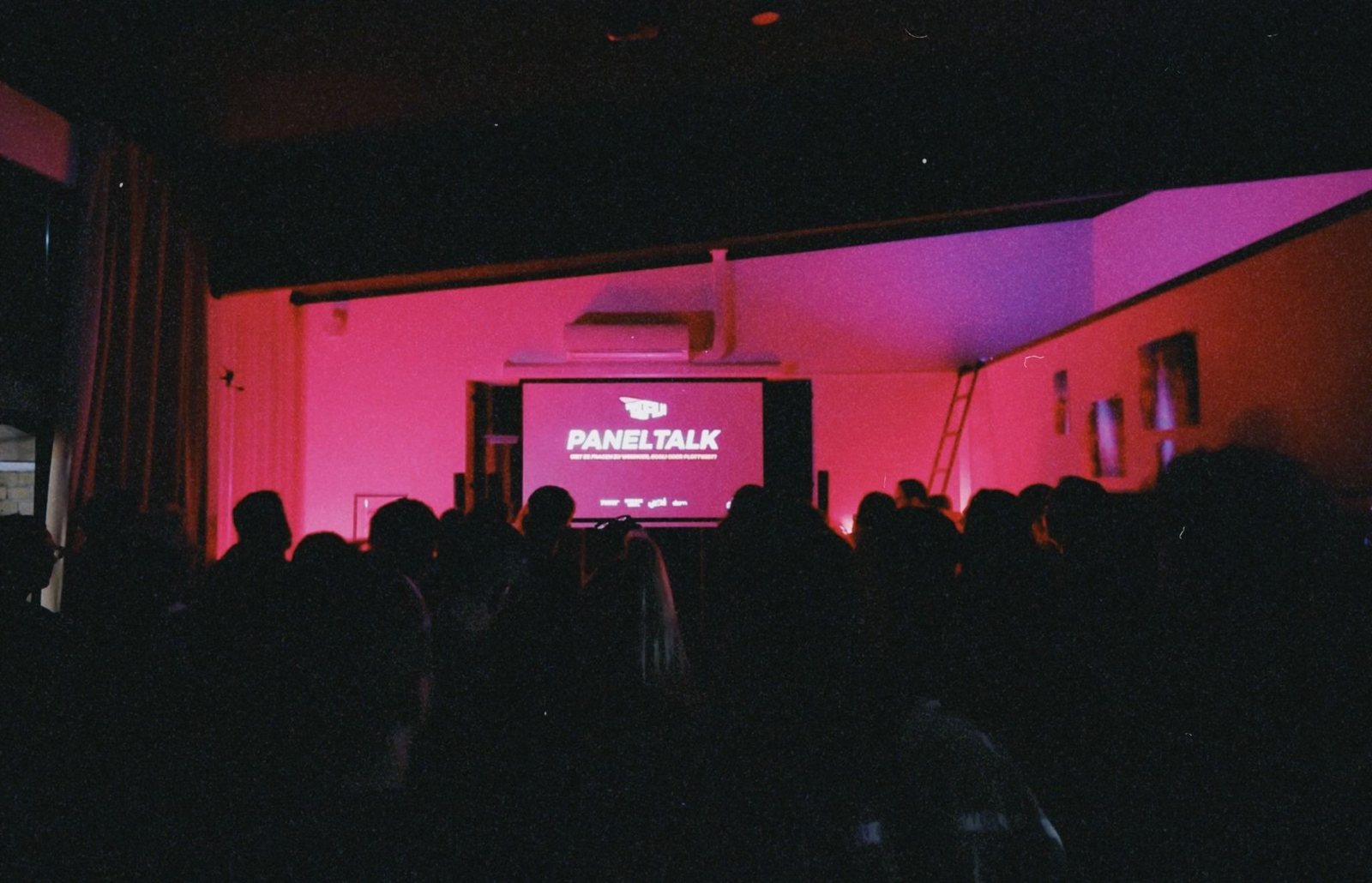 Audience in a red-lit screening room