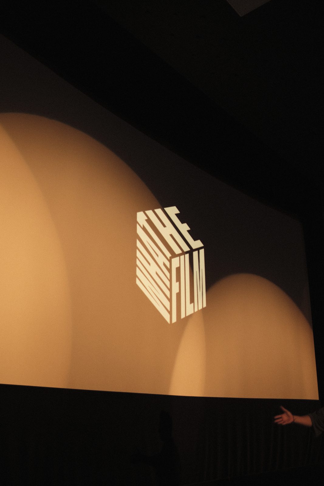 The WHAT THE FILM logo on the cinema screen